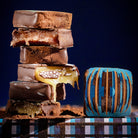 Stack of chocolate-dipped treats with one melting, on a dark background